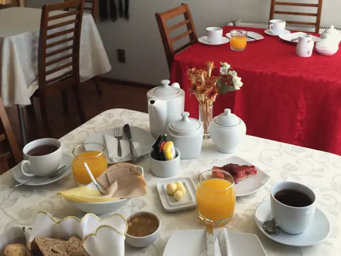 Desayuno con jugo, té, kuchen, jamón y queso