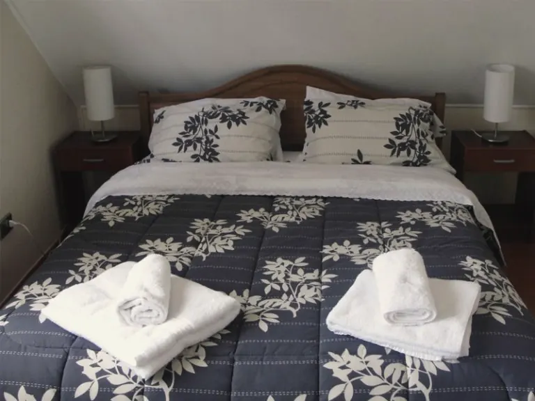 Habitación matrimonial con cama de dos plazas y toallas sobre la cama