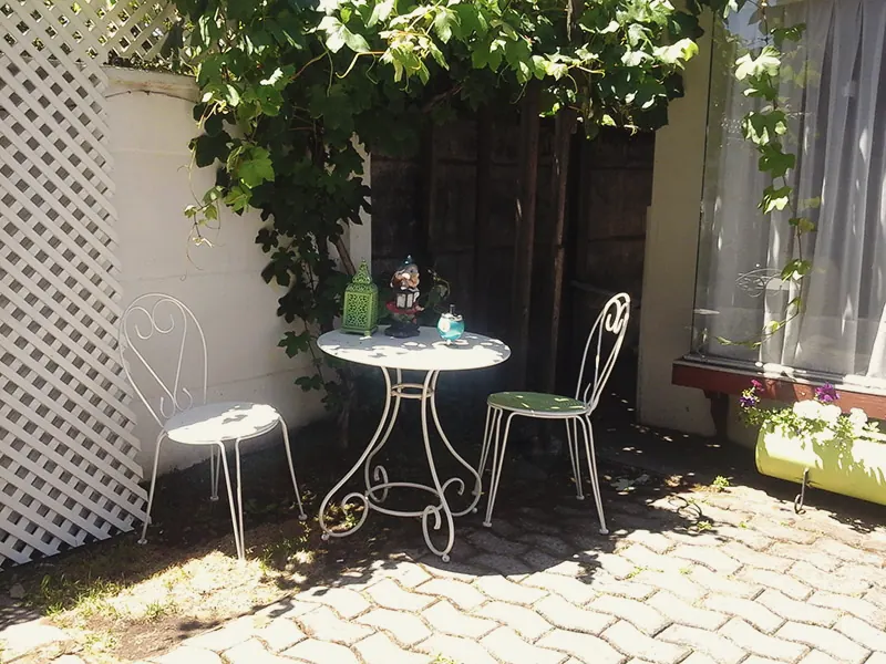 Patio con mesa de jardín y parrón
