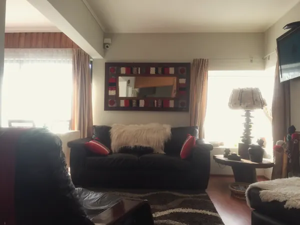 Sala de estar con sillón de cuero y espejo de marco tejido
